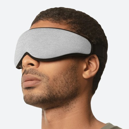 Man wearing grey Ostrich Pillow eye mask