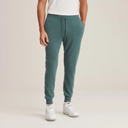 Man in green Naadam cashmere joggers on beige background